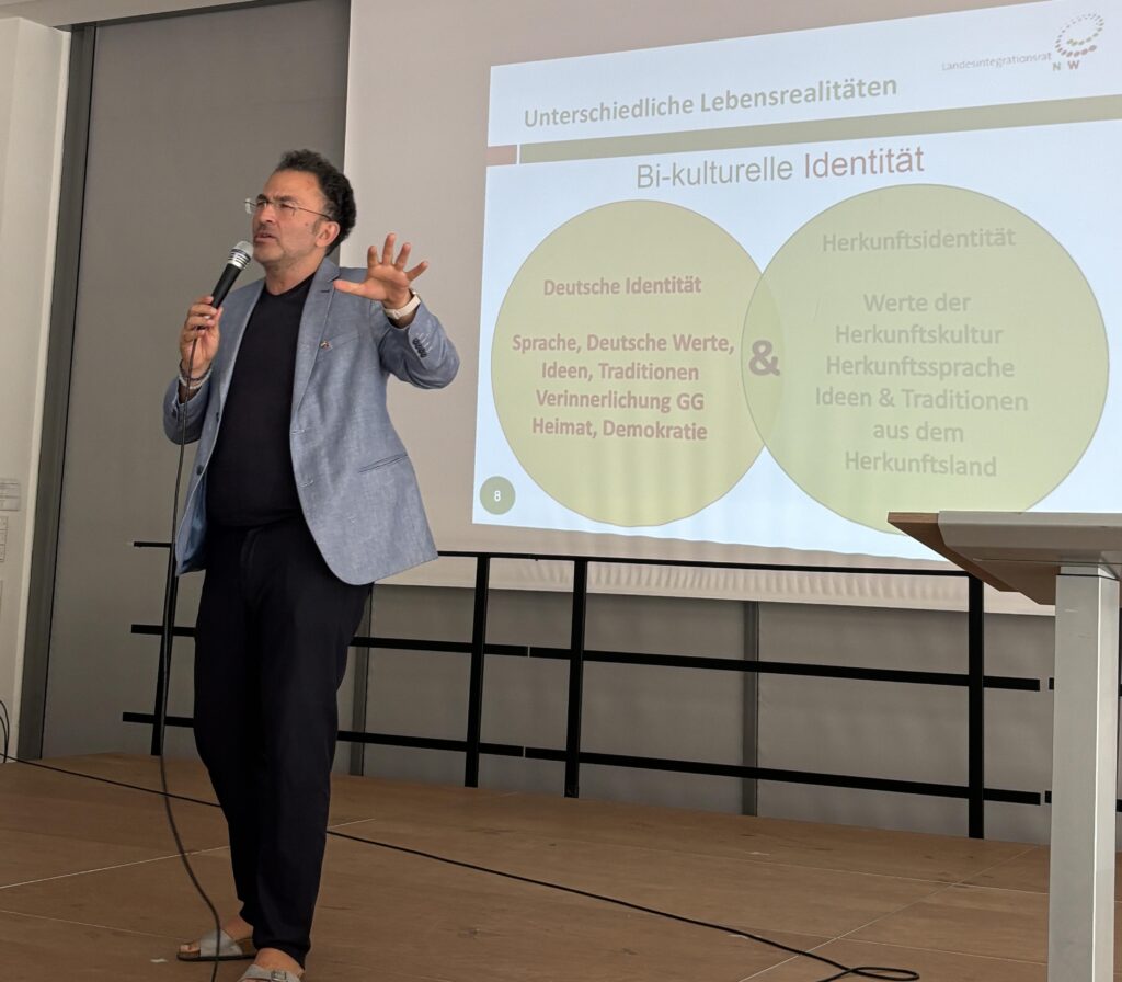 Fatih Çevikkollu auf der Bühne der Aula der Schule am See